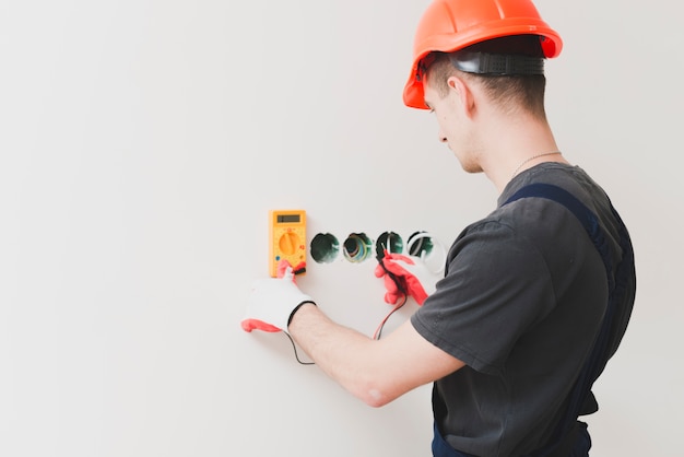 Free photo man making cable voltage measure