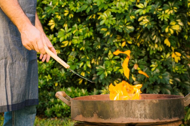 庭でグリルで火を作る男
