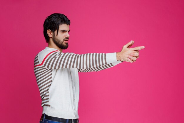 Man making gun symbol in the hand. 