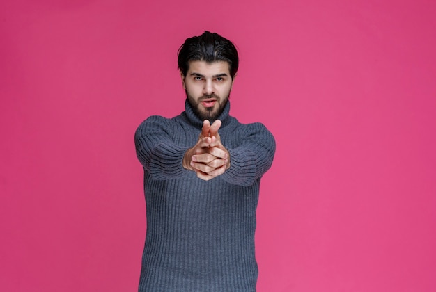 Man making hand gun sign.