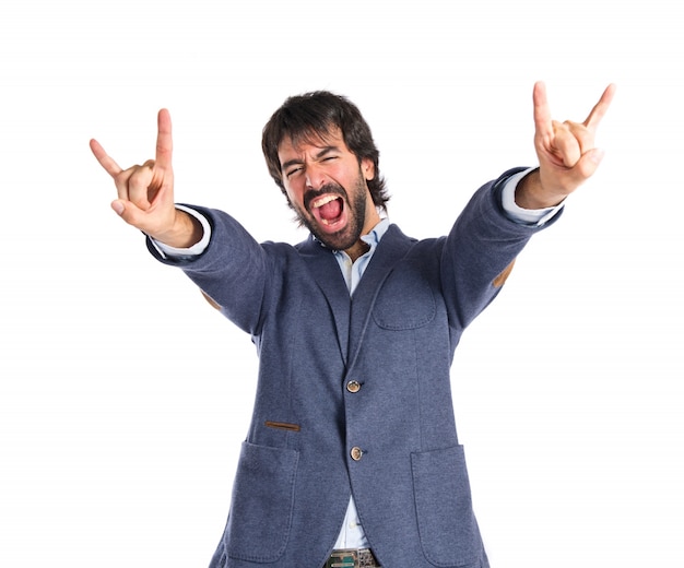 Man making horn gesture over white background