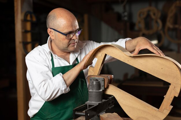 彼のワークショップで楽器を作る男