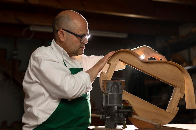 Foto gratuita uomo che costruisce strumenti nel suo laboratorio