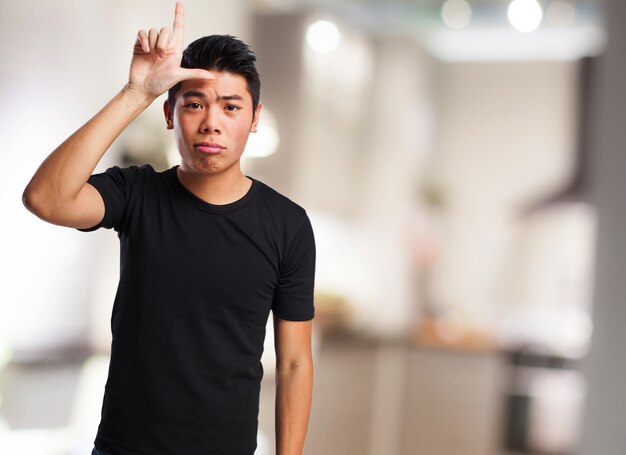 Man making a "loser" gesture with his hand