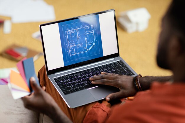 컬러 팔레트와 노트북을 사용하여 집을 개조하는 계획을 세우는 남자