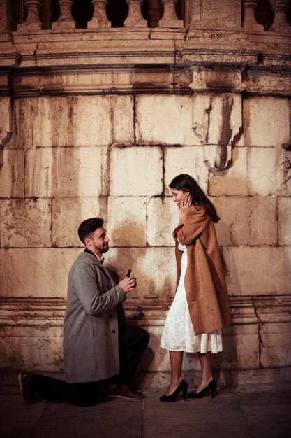 Man making proposal to young woman in street