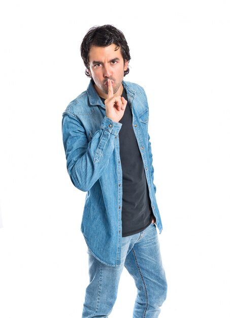 Man making silence gesture over isolated white background