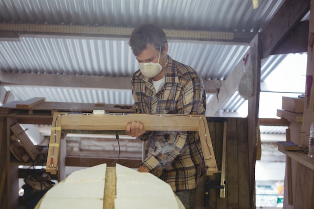 Free photo man making surfboard