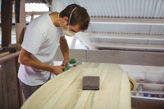 Free photo man making surfboard