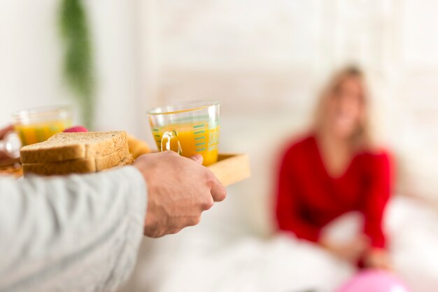 Man making a surprise breakfast in bed for his girlfriend