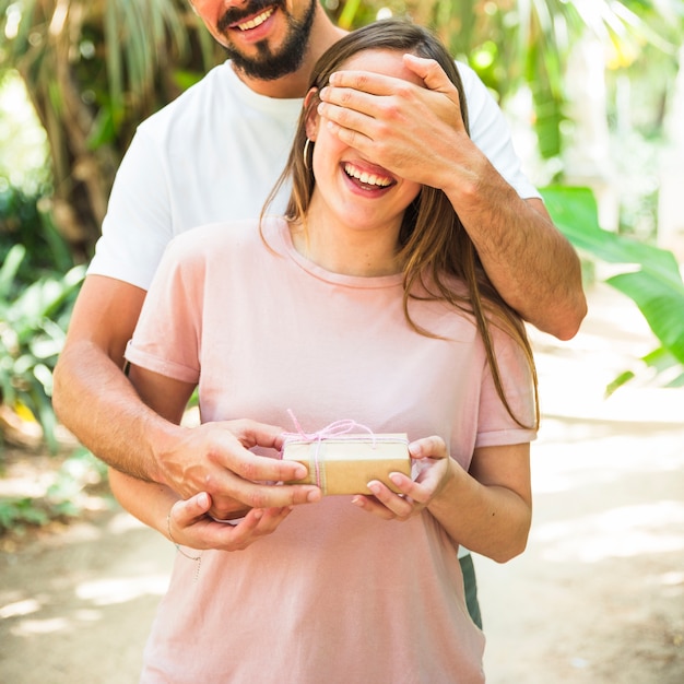 Man making surprise with gift for his girlfriend