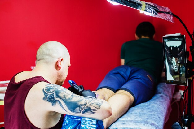 Man making tattoo on leg in studio