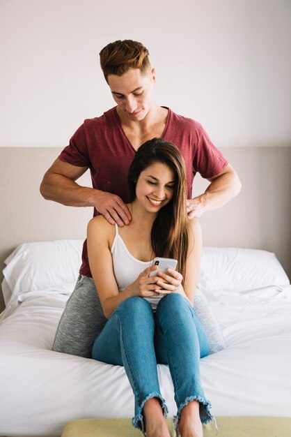 Человек, массаж плеча женщины на кровати