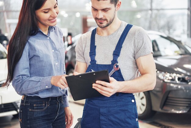 A man mechanic and woman customer discussing repairs done to her vehicle