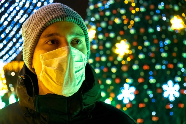 의료 마스크 남자와 밤에 겨울 재킷, 키시 나우, 몰도바의 배경에 Chrismas 장식