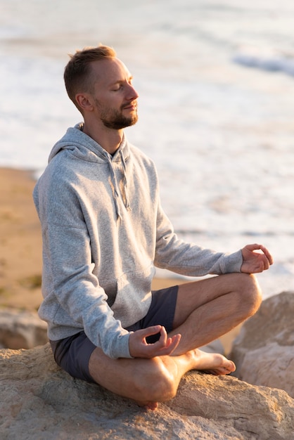 ビーチで瞑想する男