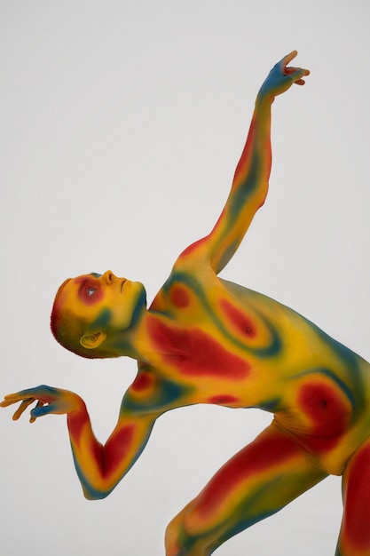 Бесплатное фото Модель человека позирует с красочной росписью тела