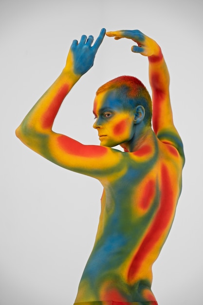 Бесплатное фото Модель человека позирует с красочной росписью тела