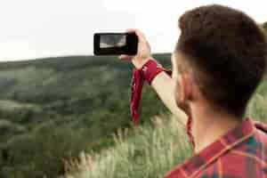 Free photo man in nature taking selfie