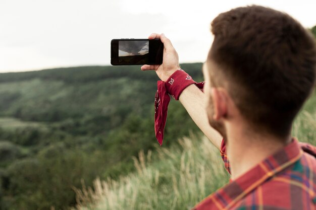 man in nature taking selfie
