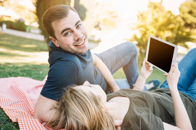 Man near woman with tablet looking at camera