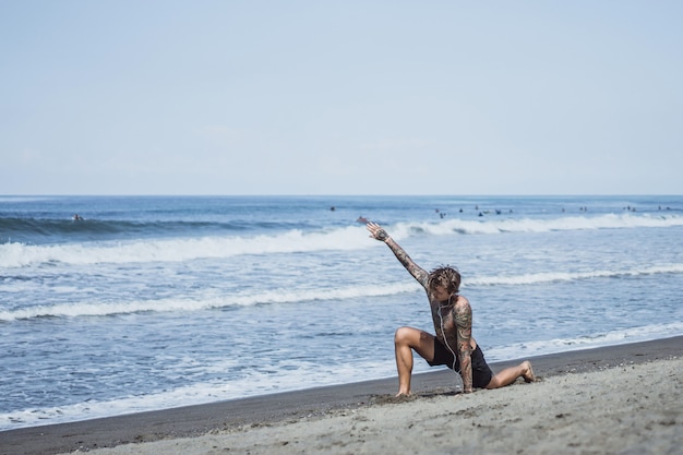 a man on the ocean coast is engaged in sports, doing gymnastics