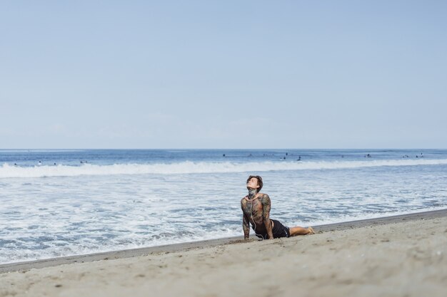 海岸沿いの男は体操をしてスポーツに従事している