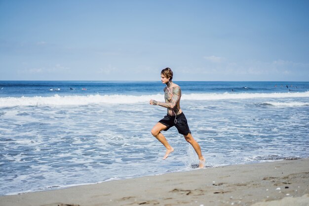 a man on the ocean coast running along the seashore