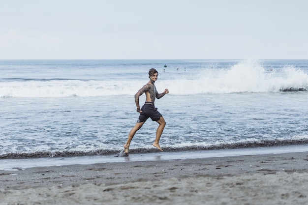 a man on the ocean coast running along the seashore