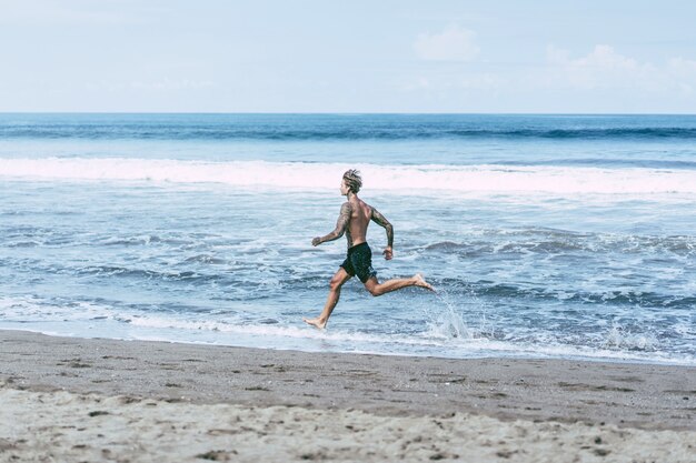 a man on the ocean coast running along the seashore