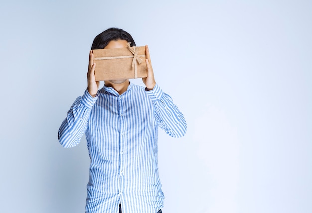 Man offering a cardboard gift box. High quality photo