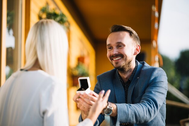 Man offering engagement ring to her girlfriend