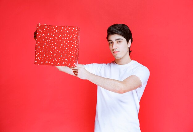 Man offering a red gift box in valentine day