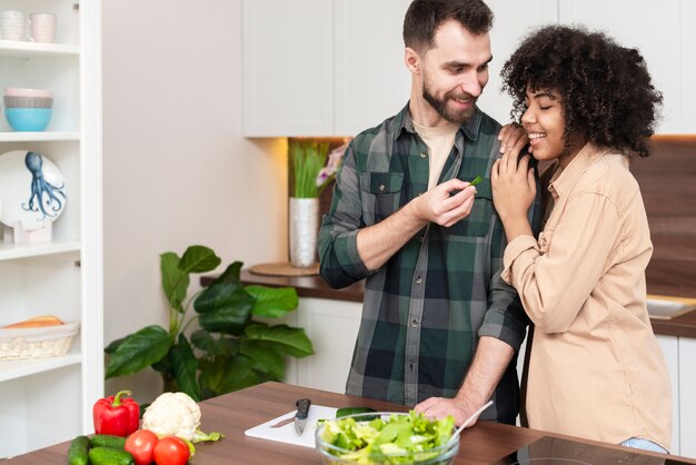 彼女のガールフレンドに野菜のスライスを提供している男