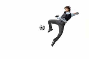 Free photo man in office clothes playing football or soccer with ball on white space. unusual look for businessman in motion, action. sport, healthy lifestyle.