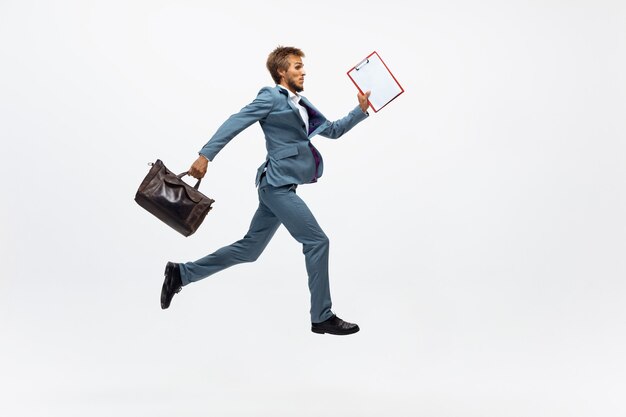 Free photo man in office clothes running jogging on white