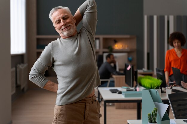 Uomo in ufficio che si allunga durante una giornata lavorativa