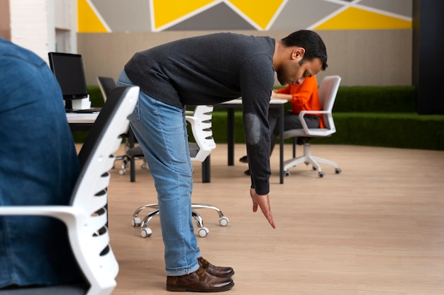 Man at the office stretching during a work day