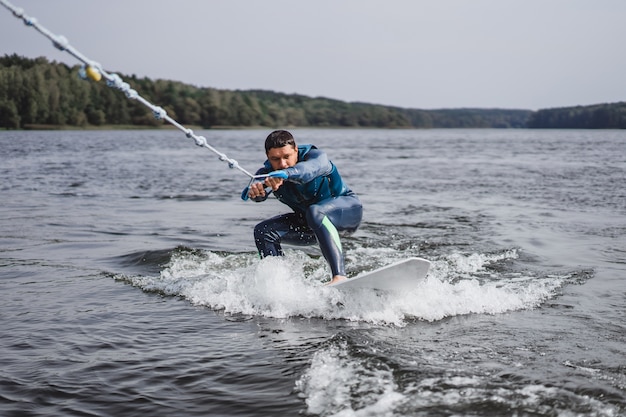 無料写真 wakesurfingの男。ボートからの波。