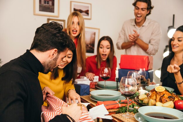 Man opening gift at christmas dinner