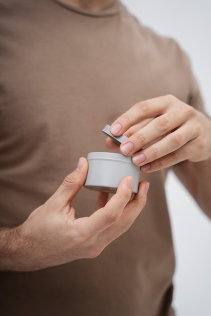 Man opening lotion jar