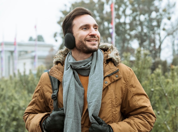 Man outdoors in the winter wearing ear muffs