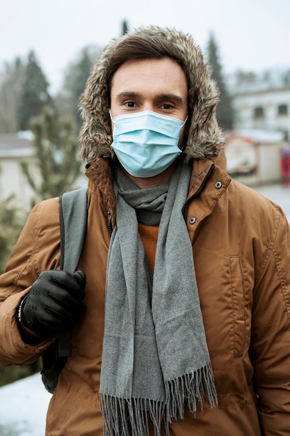 Man outdoors in the winter wearing medical mask