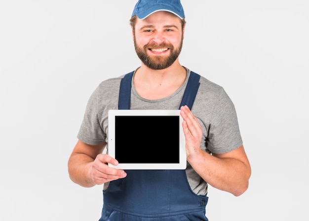 Free photo man in overall holding tablet with blank screen