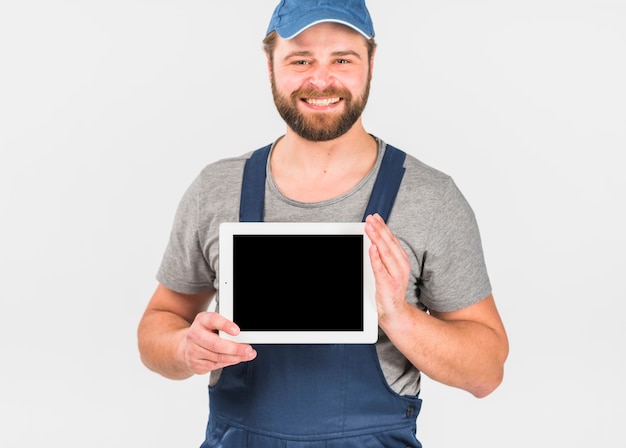 Man in overall holding tablet with blank screen