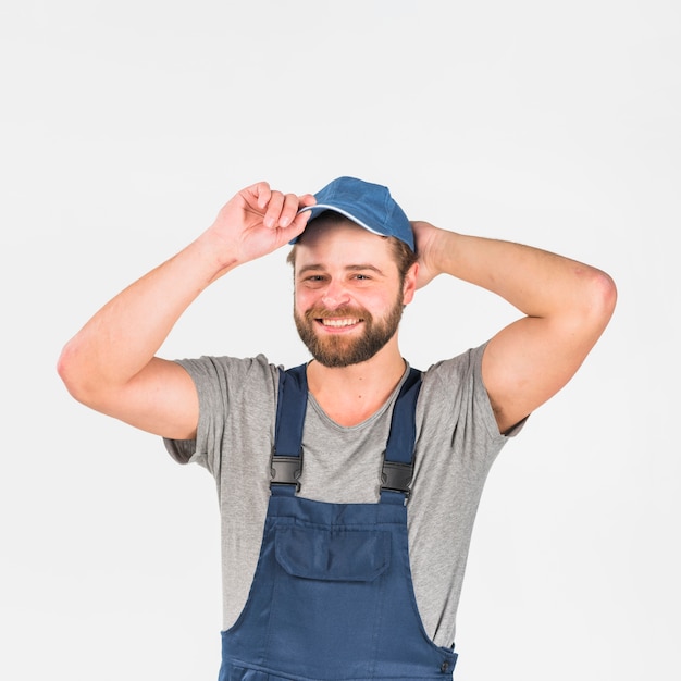 Free photo man in overall putting cap on head