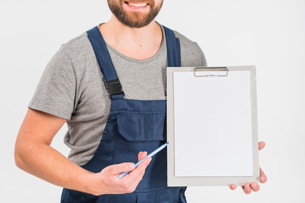 Man in overall showing clipboard with blank paper 