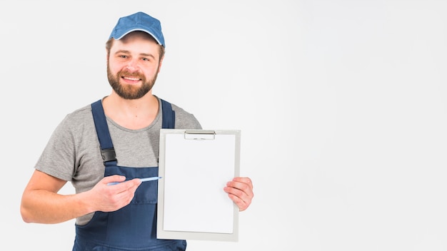 Man in overall showing clipboard with paper 