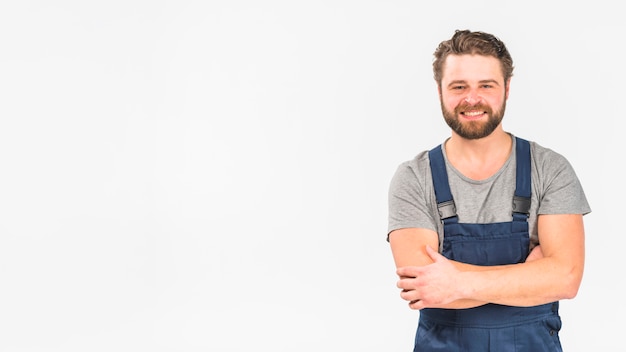 Man in overall smiling with crossed arms 