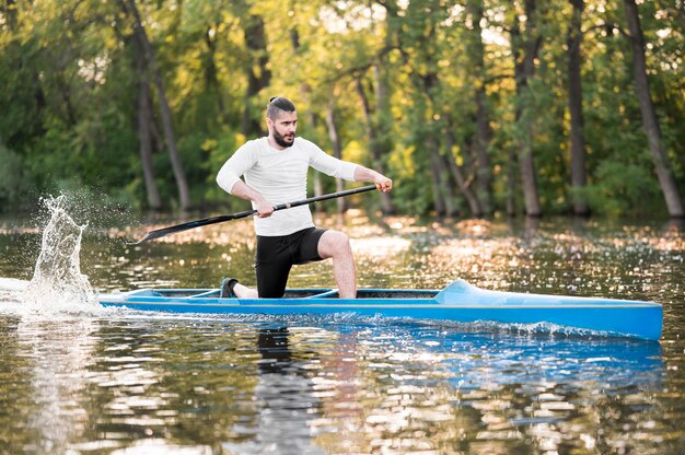 Man paddling in blue canoe